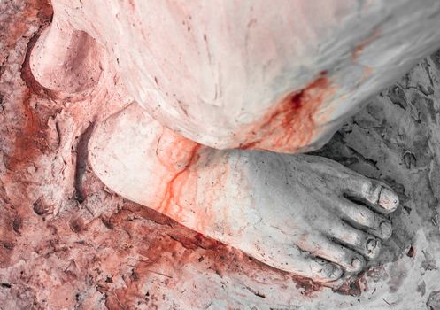 Extreme close-up of the feet of Jesus Christ bloodied. Top view. Shallow depth of field.