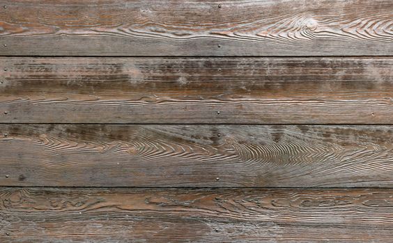 Textural image: surface of dark roughly polished wooden boards.