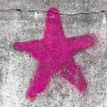 Pink star painted on grungy wall