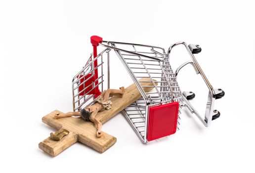 Shopping cart overturned with crucifix on the ground. Conceptual representation of commodification of religion, loss of faith, blasphemy.