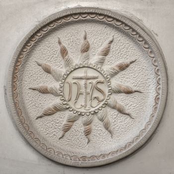 Old IHS sign (Christogram) sculpted above stone door.