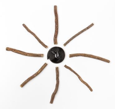 Liqorice roots and black wheel on white background. Top view.