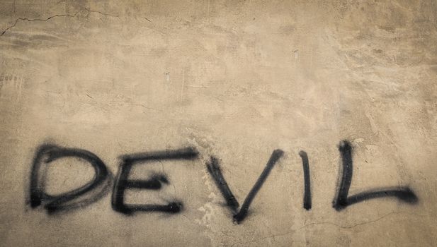 The word "devil" on grungy wall