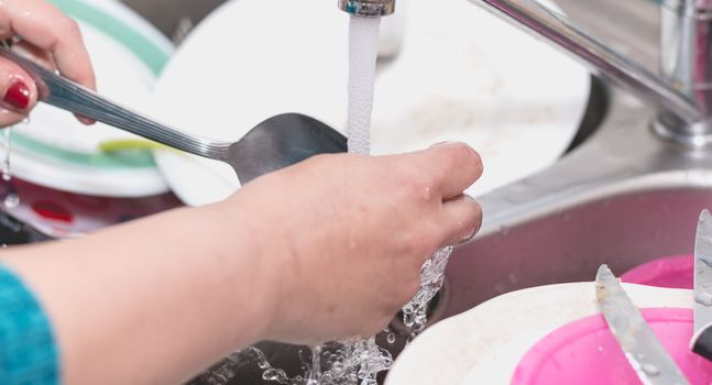 Close-up of the hand of a woman doing dishes