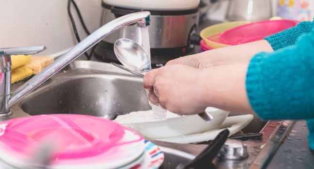 Close-up of the hand of a woman doing dishes