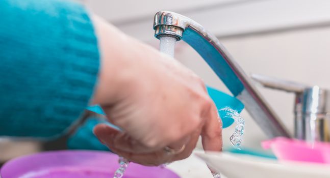 Close-up of the hand of a woman doing dishes