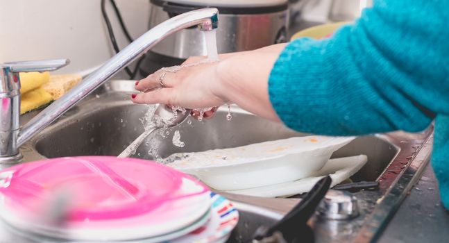 Close-up of the hand of a woman doing dishes