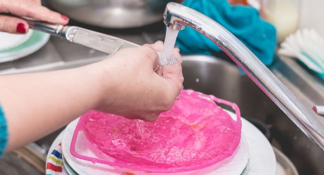 Close-up of the hand of a woman doing dishes