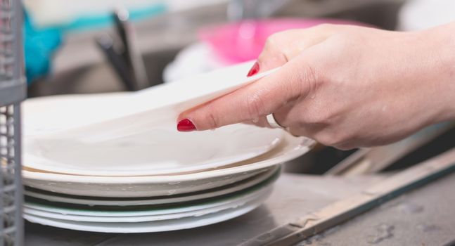 Close-up of the hand of a woman doing dishes