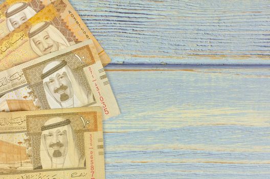 Saudi Arabia money on wooden background.
