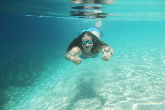 Woman swimming underwater in blue transparent sea water in summer Croatia