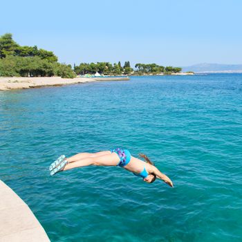 Girl dives into blue sea waves, Supetar, Brac island, Croatia