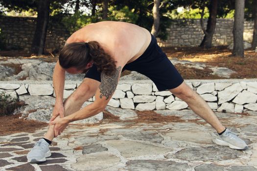 A shot of a sport mid adult man stretching outdoors