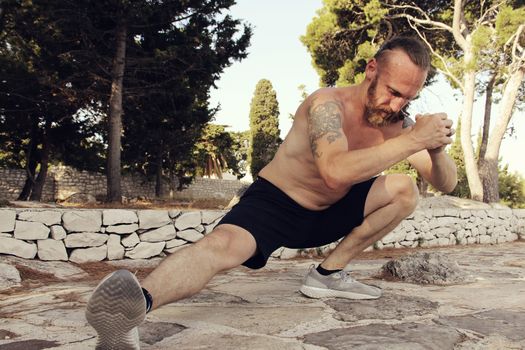 A shot of a sport mid adult man stretching outdoors