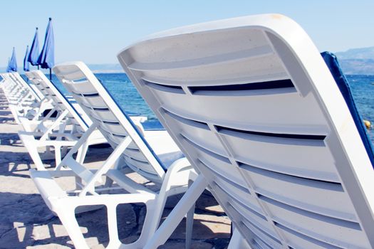 Rows of empty chaise-lounges over sea background, Supetar, Brac island, Croatia