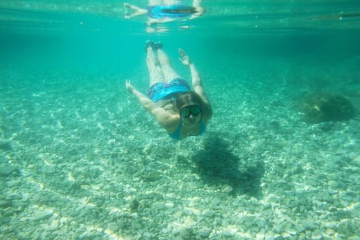 Woman swimming underwater in mediterranean adriatic sea in Croatia