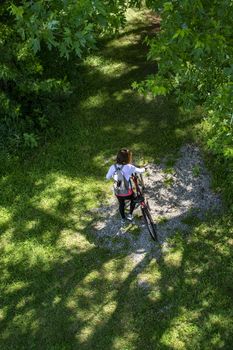 Girl with a backpack sits on a red bike