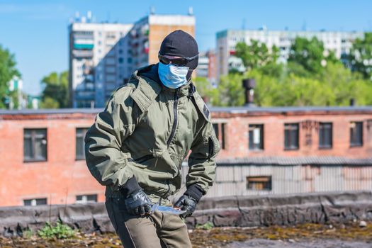 Runaway armed criminal in balaclava and medical mask