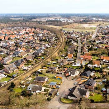 Aerial view of a small village in Lower Saxony, which is cut up by a single-lane railway line, made with drone