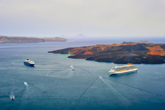 Cruise ships and tourist boats in sea. Greek isaldn Santorini, Greece. Toy camera tilt shift miniature effect