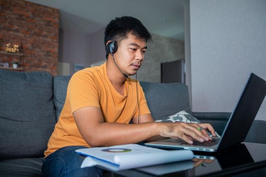 Asian businessmen is using notebook computers and wear headphones for online meetings and working from home.