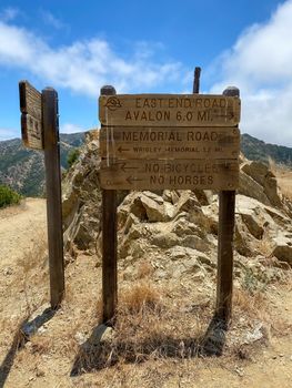 Wooden sign board with direction on the hiking trails on the top of Santa Catalina Island mountains. California, USA