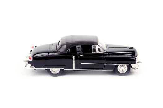 Old style black model car on white background.