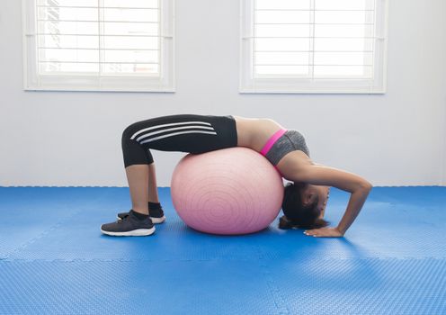 Woman doing fitness in a gym on a ball in fitness club,Young asian women working out