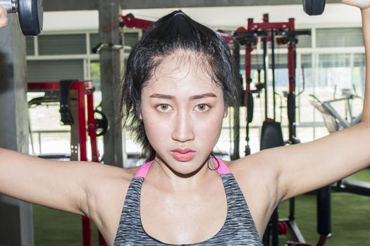 Portrait asian women  training in gym,Woman Lifting Weights,Close up  Fitness woman lifting weights