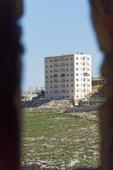 Skyscraper in the suburb of Karak in Jordan, taken from the loophole at the tower of the crusader castle, middle east