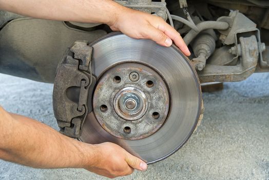 Old and dirty rear dump break of the vehicle for repair. Brakes on a car with removed wheel. Detail image of cars break assembly before repair