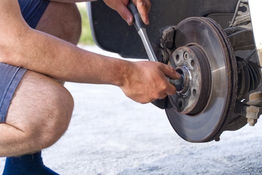 Old and dirty rear dump break of the vehicle for repair. Brakes on a car with removed wheel. Detail image of cars break assembly before repair