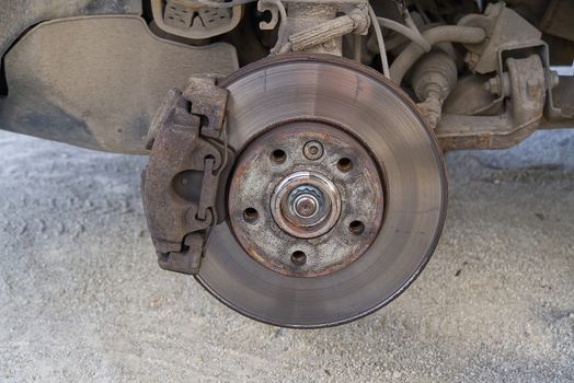 Old and dirty rear dump break of the vehicle for repair. Brakes on a car with removed wheel. Detail image of cars break assembly before repair