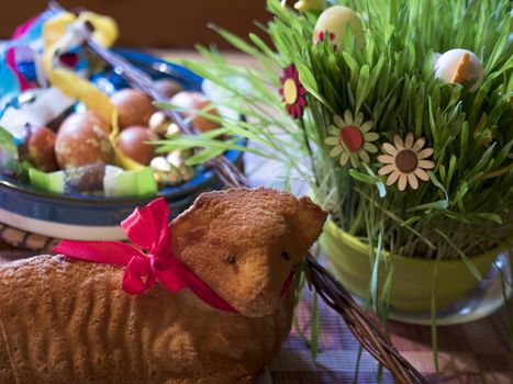 Homemade Paschal lamb cake and Colorful Painted easter eggs and Pomlazka - traditional braided whip from pussy willow and decorated green sprouts, selective focus