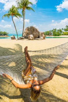 Woman relaxing at the beach on a hammock