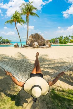 Woman relaxing at the beach on a hammock