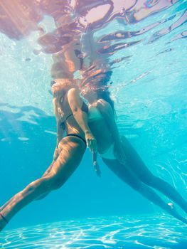 Friends underwater swimming in the pool