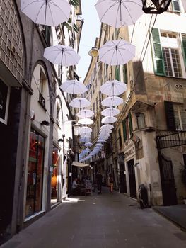 Genova, Italy - 06/01/2020: Bright abstract background of jumble of rainbow colored umbrellas over the city celebrating gay pride