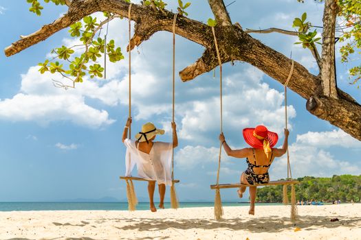 Two beautiful Women on a swing at the beach in Thailand
