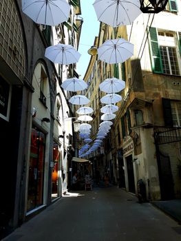 Genova, Italy - 06/01/2020: Bright abstract background of jumble of rainbow colored umbrellas over the city celebrating gay pride