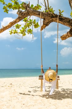 Beautiful Woman on  a swing at the beach in Thailand