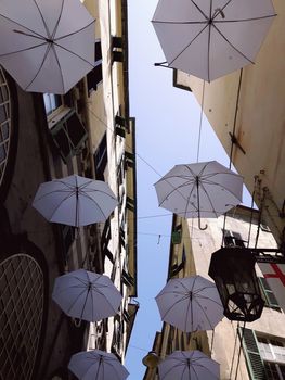 Genova, Italy - 06/01/2020: Bright abstract background of jumble of rainbow colored umbrellas over the city celebrating gay pride