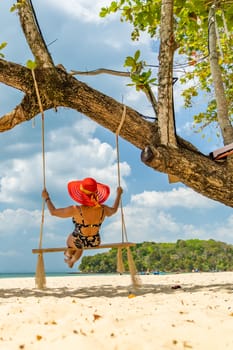 Beautiful Woman on  a swing at the beach in Thailand