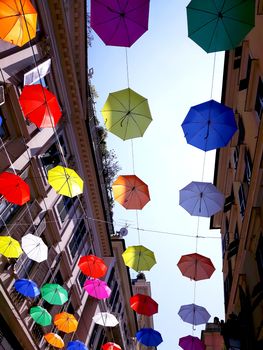 Genova, Italy - 06/01/2020: Bright abstract background of jumble of rainbow colored umbrellas over the city celebrating gay pride