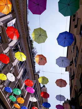 Genova, Italy - 06/01/2020: Bright abstract background of jumble of rainbow colored umbrellas over the city celebrating gay pride