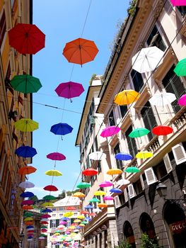 Genova, Italy - 06/01/2020: Bright abstract background of jumble of rainbow colored umbrellas over the city celebrating gay pride