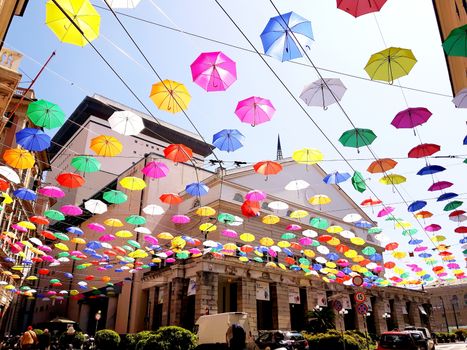 Genova, Italy - 06/01/2020: Bright abstract background of jumble of rainbow colored umbrellas over the city celebrating gay pride