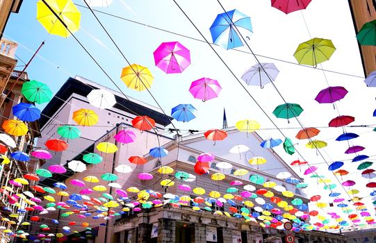 Genova, Italy - 06/01/2020: Bright abstract background of jumble of rainbow colored umbrellas over the city celebrating gay pride