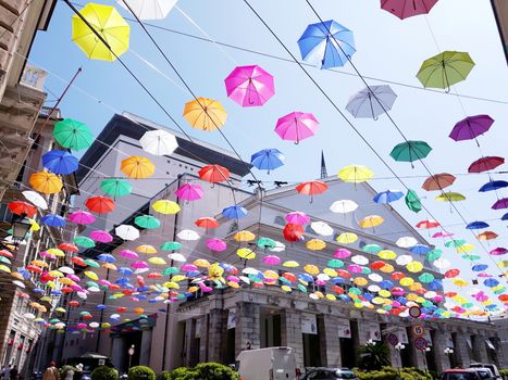 Genova, Italy - 06/01/2020: Bright abstract background of jumble of rainbow colored umbrellas over the city celebrating gay pride