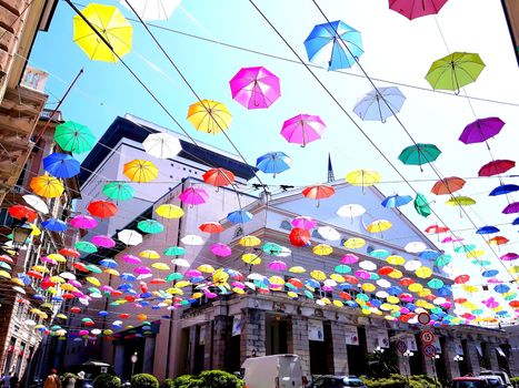 Genova, Italy - 06/01/2020: Bright abstract background of jumble of rainbow colored umbrellas over the city celebrating gay pride